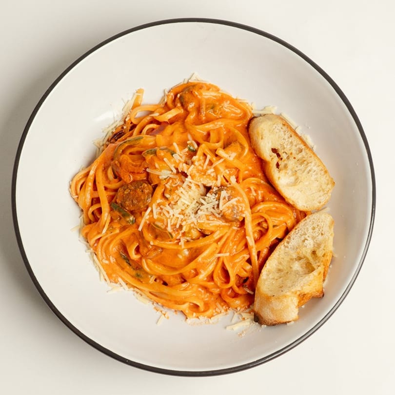 Rendezvous International Cafe's creamy tomato pasta with meatballs, parmesan, and two slices of toasted bread.