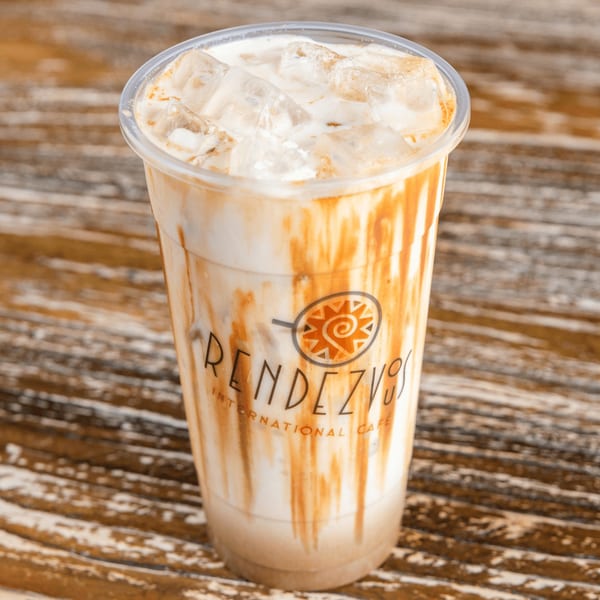 Iced caramel latte in a clear plastic cup with the Rendezvous International Cafe logo.
